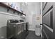 Well-organized laundry room with dark gray appliances, a storage shelf, and tile flooring at 3599 Chalmers Dr, Bargersville, IN 46106