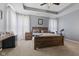 Inviting main bedroom with tray ceilings, a large bed, soft lighting, and cozy carpet at 3599 Chalmers Dr, Bargersville, IN 46106