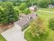 Aerial view of a spacious home with an attached garage and long driveway surrounded by green lawns and mature trees at 391 W 500 S, Anderson, IN 46013