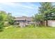 Backyard view featuring a covered patio, established garden, and manicured lawn, perfect for outdoor enjoyment at 391 W 500 S, Anderson, IN 46013