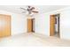 Neutral bedroom with three doorways, neutral walls and carpeting, and a ceiling fan at 391 W 500 S, Anderson, IN 46013