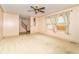 Bright living room with neutral carpeting, a ceiling fan, and large windows, offering a comfortable living space at 391 W 500 S, Anderson, IN 46013