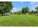 The backyard features a large grassy area with mature trees, outbuildings, and a fire pit at 406 W Mcgregor Rd, Indianapolis, IN 46217