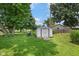 The backyard features a storage shed, mature trees, and a grassy area, all enclosed by a fence at 406 W Mcgregor Rd, Indianapolis, IN 46217