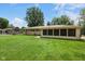 View of the house from the backyard showing the yard, sunroom, and brick exterior at 406 W Mcgregor Rd, Indianapolis, IN 46217
