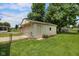 View of the detached one car garage with mature shade trees in the background and a chain link fence in the front at 406 W Mcgregor Rd, Indianapolis, IN 46217