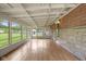 The sunroom is surrounded by windows and has a wood floor, beamed ceiling, and exterior access at 406 W Mcgregor Rd, Indianapolis, IN 46217