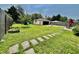 Large backyard featuring a playset, stone pathway, lush green grass, and patio area at 419 N 14Th Ave, Beech Grove, IN 46107