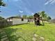 Backyard featuring lush green lawn, stone walkway, play set and detached garage at 419 N 14Th Ave, Beech Grove, IN 46107