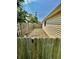 View of a backyard showcasing a wooden fence, siding, and gravel area adjacent to the garage at 419 N 14Th Ave, Beech Grove, IN 46107
