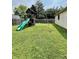 Spacious backyard featuring a wooden playset with a slide, swing set and lush green grass at 419 N 14Th Ave, Beech Grove, IN 46107