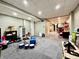 Finished basement with carpeted area, toy storage, drum set, and partial view into adjacent bar area at 419 N 14Th Ave, Beech Grove, IN 46107