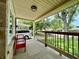 Covered front porch with black railing and a red bench, providing a charming view of the neighborhood at 419 N 14Th Ave, Beech Grove, IN 46107