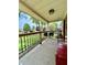 Inviting covered front porch with wood railing, a red bench, and view of landscaped front yard at 419 N 14Th Ave, Beech Grove, IN 46107