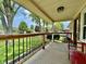 Inviting covered front porch with wood railing, a red bench, and view of landscaped front yard at 419 N 14Th Ave, Beech Grove, IN 46107