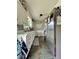 Galley kitchen featuring white cabinets, marble countertops, tile flooring, and stainless steel refrigerator at 419 N 14Th Ave, Beech Grove, IN 46107