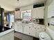 This kitchen is equipped with white cabinets, marble countertops, stainless steel sink and modern fixtures at 419 N 14Th Ave, Beech Grove, IN 46107