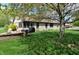 Landscaped backyard featuring patio, screened in porch, brick home, and mature tree for shade at 421 Kingsway Ct, Mooresville, IN 46158