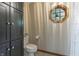 Well-lit bathroom featuring a unique window, toilet and dark cabinetry at 421 Kingsway Ct, Mooresville, IN 46158