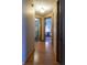 Hallway leading to bedrooms and laundry area featuring wood floors and neutral paint at 421 Kingsway Ct, Mooresville, IN 46158