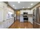 Bright kitchen featuring stainless steel appliances, white cabinets, and hardwood floors at 421 Kingsway Ct, Mooresville, IN 46158