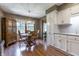 Bright kitchen featuring stainless steel appliances, white cabinets, and hardwood floors next to dining area at 421 Kingsway Ct, Mooresville, IN 46158