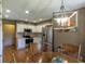 Bright kitchen featuring stainless steel appliances, white cabinets, and hardwood floors next to dining area at 421 Kingsway Ct, Mooresville, IN 46158