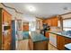 Functional kitchen with stainless steel refrigerator, wooden cabinets, and center island at 4697 W Ridge Dr, Columbus, IN 47203