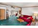 Cozy living area with a large red sofa, green carpet, and open view to the kitchen at 4697 W Ridge Dr, Columbus, IN 47203