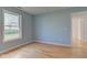 Bright bedroom featuring wood floors, light blue walls, and a window for natural light at 524 S Meridian S St, Lebanon, IN 46052
