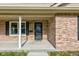 Detailed view of the front porch with brick columns and a secure screen door entrance at 524 S Meridian S St, Lebanon, IN 46052