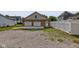 Garage with white doors, concrete driveway, and partial gravel area with a white privacy fence at 524 S Meridian S St, Lebanon, IN 46052