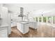 Open kitchen with a large island, stainless steel vent hood, and hardwood floors throughout at 545 Pitney Dr, Noblesville, IN 46062