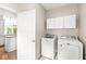 Convenient laundry room featuring a washer, dryer, storage cabinets, and doorway to kitchen at 545 Pitney Dr, Noblesville, IN 46062