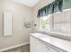 Functional laundry room with a sink, cabinets, tile floors, and a bright window view at 545 Pitney Dr, Noblesville, IN 46062