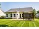 Home's back exterior showcasing a patio, manicured lawn, vinyl siding, and partial fencing at 5883 Hollow Oak, Carmel, IN 46033