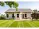 Back exterior view highlighting a patio, pristine lawn, light siding, and partial fencing at 5883 Hollow Oak, Carmel, IN 46033