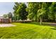 Large, well-maintained backyard with lush green grass, mature trees, wooden fence, and patio area at 5883 Hollow Oak, Carmel, IN 46033