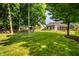 Expansive backyard featuring a well-kept lawn, mature trees providing shade, and a view of the home at 5883 Hollow Oak, Carmel, IN 46033