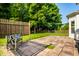 Private backyard features stone patio, bench, manicured lawn, and mature trees at 5883 Hollow Oak, Carmel, IN 46033