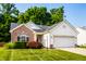 Charming home with brick accents, a two-car garage, and a well-maintained lawn on a sunny day at 5883 Hollow Oak, Carmel, IN 46033