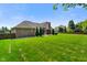 Expansive green backyard, outlined by a wooden fence and privacy trees creating a private oasis at 648 Shakespeare Dr, Avon, IN 46123