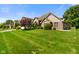 Attractive brick home with a sprawling green lawn, mature trees, and well-maintained landscaping at 648 Shakespeare Dr, Avon, IN 46123