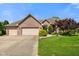 Charming brick home with a manicured front yard, mature landscaping, and a spacious three-car garage at 648 Shakespeare Dr, Avon, IN 46123