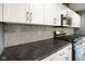 Gourmet kitchen with stainless steel gas range and mosaic tile backsplash at 648 Shakespeare Dr, Avon, IN 46123
