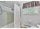 Clean bathroom with a shower-tub combo, framed window, and modern toilet at 703 Chapel Hill W Dr, Indianapolis, IN 46214