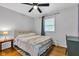 Well-lit bedroom with hardwood floors, a ceiling fan, and modern decor at 703 Chapel Hill W Dr, Indianapolis, IN 46214