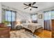 Bright bedroom with hardwood floors, floral wallpaper, and abundant natural light at 703 Chapel Hill W Dr, Indianapolis, IN 46214