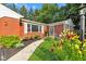 Charming front entrance with a well-manicured lawn, vibrant flowers, and a walkway leading to the door at 703 Chapel Hill W Dr, Indianapolis, IN 46214