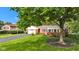Charming red brick home with attached garage, set on a lush green lawn with mature trees providing shade and beauty at 703 Chapel Hill W Dr, Indianapolis, IN 46214
